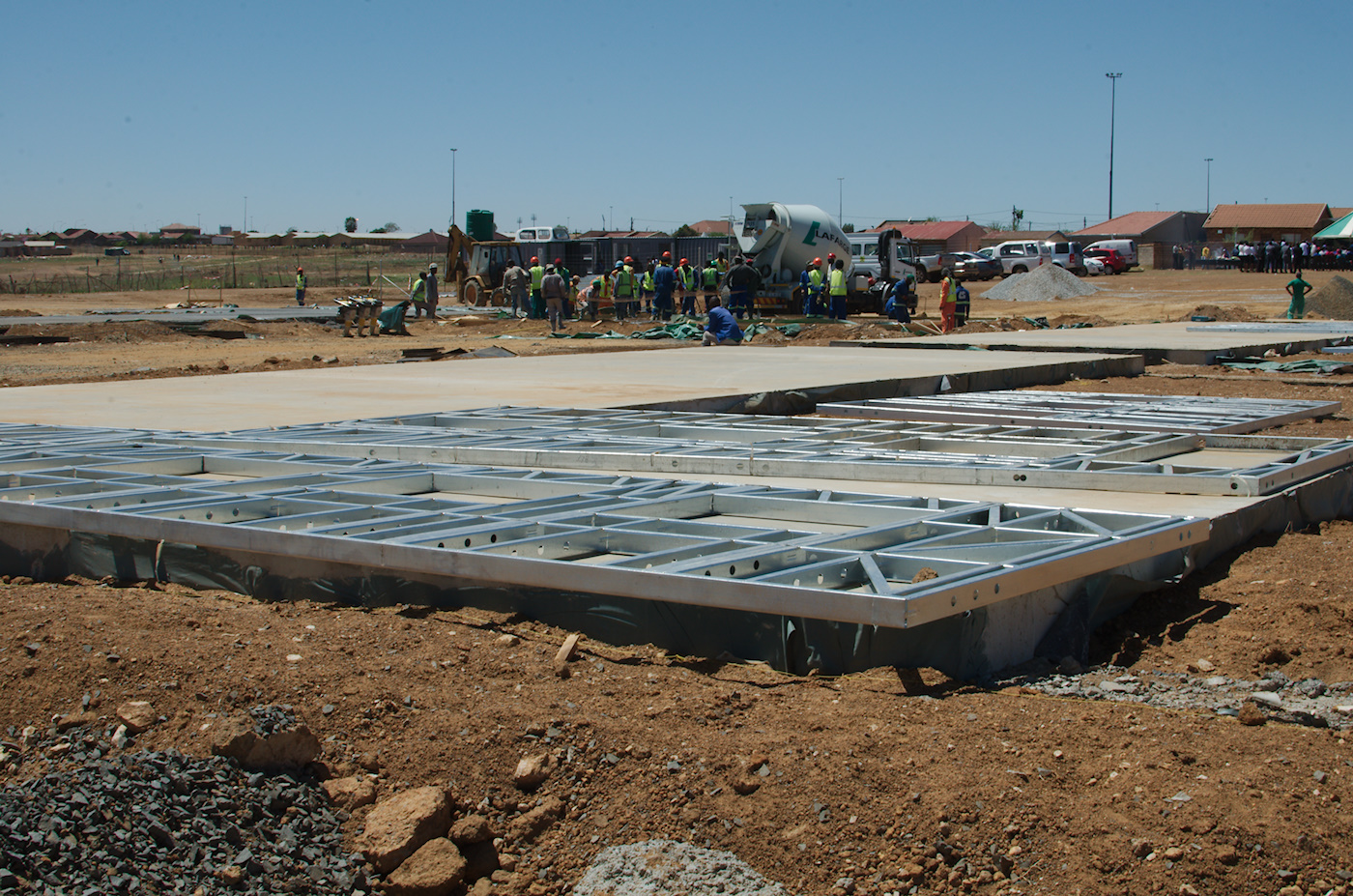 Metal bases for the classroom blocks being placed on concrete.