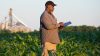 Black farmer with digital tablet in crop field